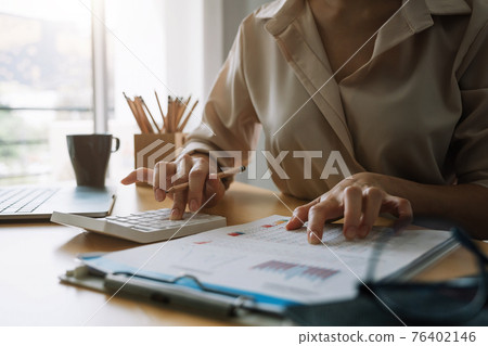 Close up Business woman or accountant using calculator with computer laptop, Business accounting, budget and loan paper at home 76402146
