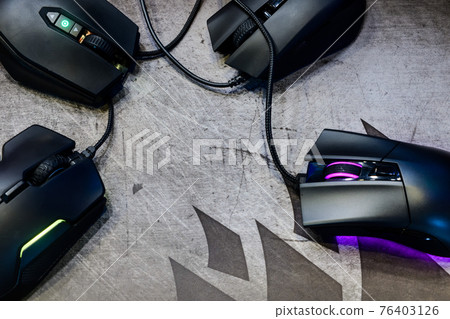 Close-up group of modern gaming mouse on black color with LED RGB light show status on working mode placing on gaming mouse pad on top-view, e-sport concept Close-up group of modern gaming mouse on black color with LED RGB light show status on working mode placing on gaming mouse pad on top-view, e-sport concept 76403126