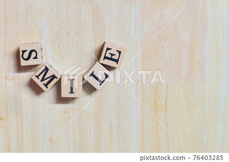Smile concept idea, wooden letters connect is curve to message on wooden desk, informative and communication about happy, close-up on top-view and copy space 76403285