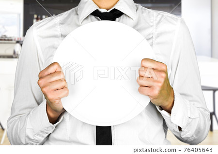 An empty plate held by a faceless waiter. Perfect shot for occupations, kitchen, no customers, pandemic, work. 76405643