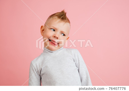 Happy boy isolated on pink studio background. Looks happy, cheerful, sincere. Copyspace. Childhood, education, emotions concept Happy boy isolated on pink studio background. Looks happy, cheerful, sincere. Copyspace. Childhood, education, emotions concept 76407776