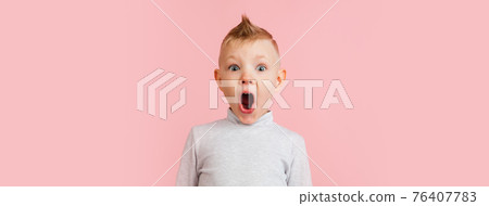 Happy boy isolated on pink studio background. Looks happy, cheerful, sincere. Copyspace. Childhood, education, emotions concept 76407783