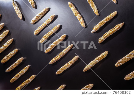 french baguette of bread hang on the black wall 76408302