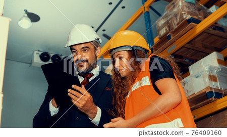 Warehouse senior manager discuss with worker in the storehouse 76409160