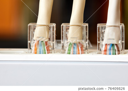 Ethernet cables connected to Desktop Switch or routerboard. Close-up, selective focus 76409826