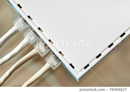 Ethernet cables connected to Desktop Switch or routerboard. Close-up, selective focus Ethernet cables connected to Desktop Switch or routerboard. Close-up, selective focus 76409827