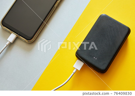 Power bank charges smartphone using a USB cable Power bank charges smartphone using a USB cable 76409830