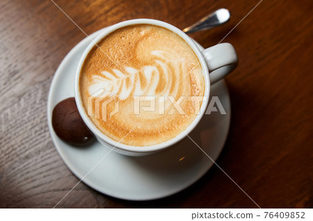 A cup of coffee. Latte with a pattern in a white cup. A cup of coffee. Latte with a pattern in a white cup. 76409852