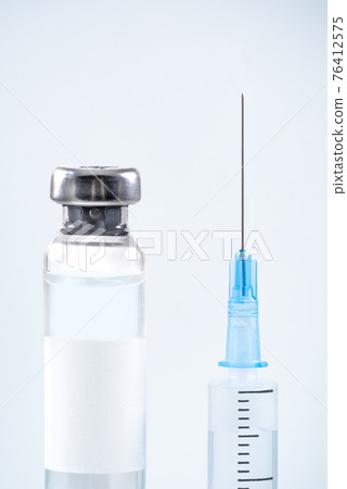 Close-up of shingle vaccine vial and syringe blue background Close-up of shingle vaccine vial and syringe blue background 76412575