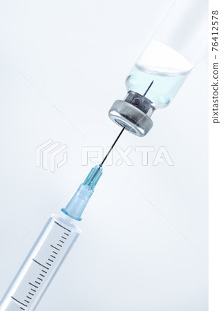 Close-up of shingle vial and syringe blue background 76412578