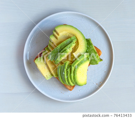 toasted bread with sliced avocado 76413433