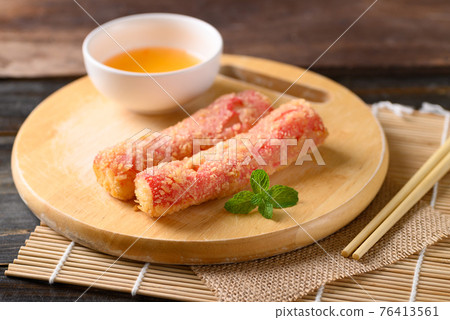 Deep fried crab sticks or surimi on wooden board eating with chili sauce 76413561