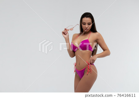 Slim woman in swimwear with sunglasses 76416611