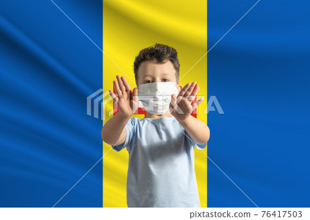 Little white boy in a protective mask on the background of the flag of Madeira. Makes a stop sign with his hands, stay at home Madeira Little white boy in a protective mask on the background of the flag of Madeira. Makes a stop sign with his hands, stay at home Madeira 76417503