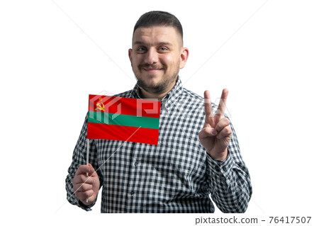 White guy holding a flag of Transnistria and shows two fingers isolated on a white background White guy holding a flag of Transnistria and shows two fingers isolated on a white background 76417507