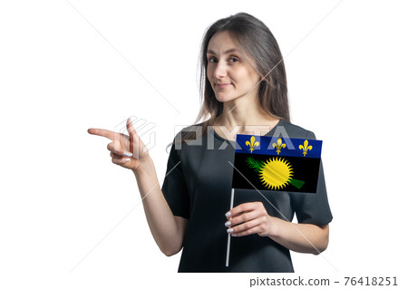 Happy young white woman holding flag Guadeloupe and points to the left isolated on a white background Happy young white woman holding flag Guadeloupe and points to the left isolated on a white background 76418251