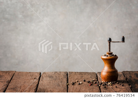 Retro pepper mill on wooden table Retro pepper mill on wooden table 76419534