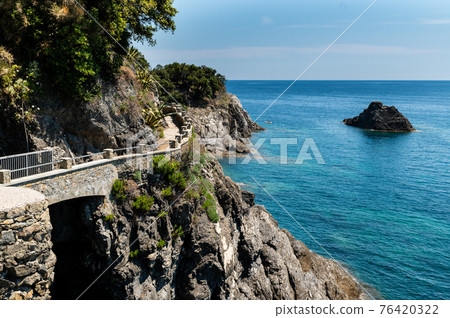 Monterosso, Liguria, Italy, June 2020. La via dell'amore panoramic path that connects the Cinque Terre: an amazing corner of coast with crystal clear waters and wild nature. Beautiful summer day. Monterosso, Liguria, Italy, June 2020. La via dell'amore panoramic path that connects the Cinque Terre: an amazing corner of coast with crystal clear waters and wild nature. Beautiful summer day. 76420322
