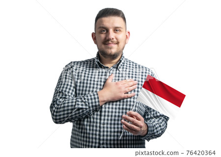 White guy holding a flag of Indonesia and holds his hand on his heart isolated on a white background With love to Indonesia 76420364