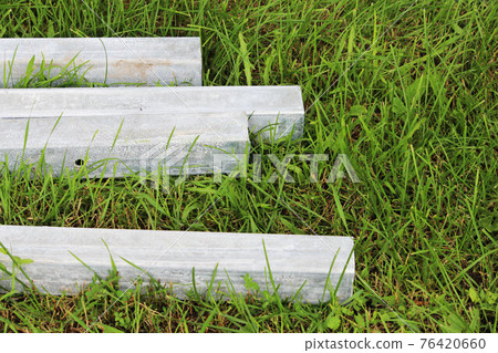 four concrete blocks lie on the grass. blanks for pillars 76420660