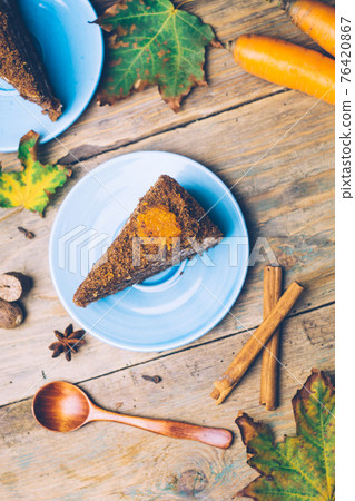 Carrot cake (homemade desserts) whith cinnamon sticks and decorated with spices on wooden background. 76420867