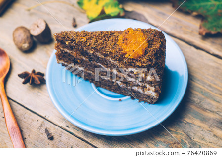 Carrot cake (homemade desserts) whith cinnamon sticks and decorated with spices on wooden background. 76420869