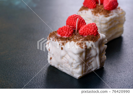 Beautiful colorful bright candle made in the form of an appetizing cake. Aromatherapy, candle with the smell of herbs Beautiful colorful bright candle made in the form of an appetizing cake. Aromatherapy, candle with the smell of herbs 76420990