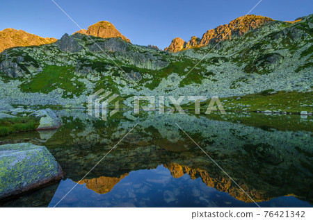Mountain landscape and glacial Taul Portii lake in Retezat National Park, Carpathian Mountains, Romania, at sunrise 76421342