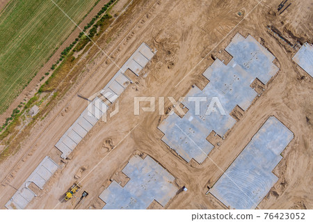 Aerial view on the preparation of the work for unfinished with foundation to new house construction in the suburbs Aerial view on the preparation of the work for unfinished with foundation to new house construction in the suburbs 76423052