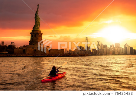 Adventurous Woman Sea Kayaking near the Statue of Liberty 76425488
