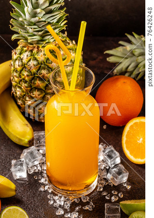 Delicious cold refreshing orange smoothie drink in cocktail glass with ananas, kiwi and banana Delicious cold refreshing orange smoothie drink in cocktail glass with ananas, kiwi and banana 76426248