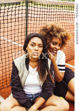 young pretty girlfriends hanging on tennis court, fashion stylish dressed swag, best friends happy smiling together 76426662