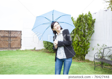 A woman holding an umbrella A woman holding an umbrella 76427448