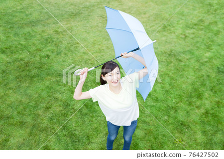 A woman holding an umbrella 76427502