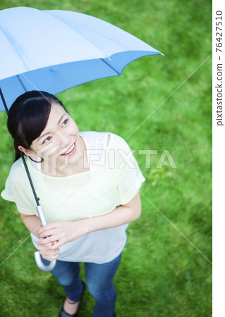 A woman holding an umbrella 76427510