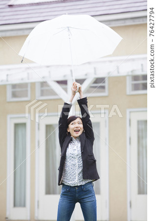 A woman holding an umbrella 76427794