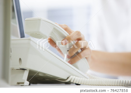 A woman talking to a telephone 76427858