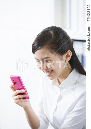 Looking at a smartphone OL 76428192