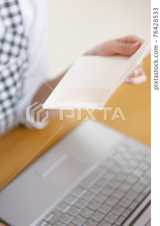 A woman holding a household account book 76428533