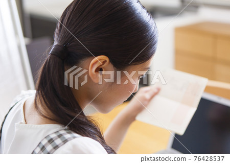 A woman holding a household account book 76428537