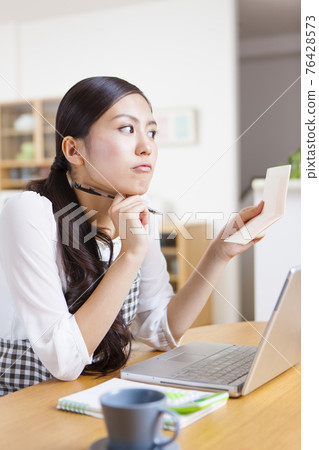 A woman holding a household account book 76428573