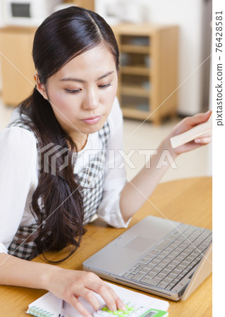 拿著家庭帳簿的婦女 76428581