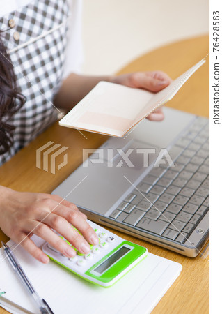 拿著家庭帳簿的婦女 76428583