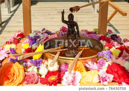 Watered Jizo and colorful fresh flowers 76430708