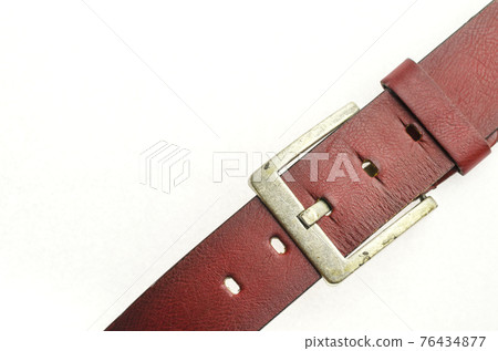 Cropped detail shot of a red leather belt on the white background. 76434877