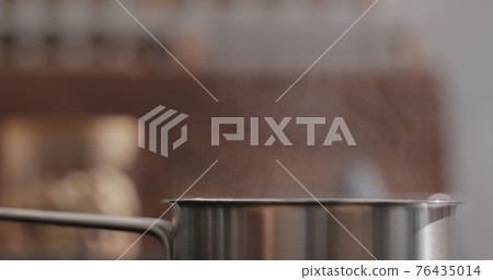 steam rising from saucepan with boiling water on kitchen closeup steam rising from saucepan with boiling water on kitchen closeup 76435014