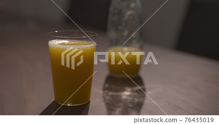 organic orange juice glass bottle and tumbler glass on walnut table organic orange juice glass bottle and tumbler glass on walnut table 76435019