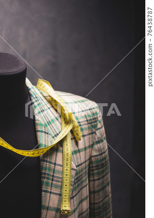 Suit jacket on male tailor mannequin and tape measure, creative concept 76438787