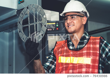 Smart factory job worker looking at machine part in manufacturing workshop Smart factory job worker looking at machine part in manufacturing workshop 76438986