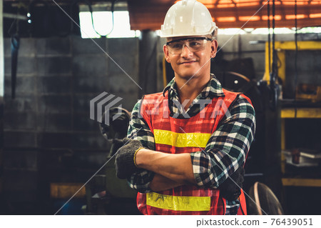 Young factory job worker or engineer close up portrait in manufacturing factory 76439051